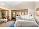 Bright bedroom with balcony access, white linens, and carpeted floors at 6 Blue Grouse Ridge Rd, Littleton, CO 80127
