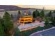 Unique three-story home with a 2-car garage and stone retaining wall, surrounded by mature trees at 6 Blue Grouse Ridge Rd, Littleton, CO 80127
