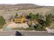 Aerial view of a three-story house with a large driveway and a hillside in the background at 6 Blue Grouse Ridge Rd, Littleton, CO 80127