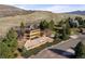 Beautiful exterior view of a multi-story home with a backdrop of rolling hills and a sunny sky at 6 Blue Grouse Ridge Rd, Littleton, CO 80127