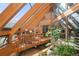 Unique indoor atrium with wood beams, large windows, and lush greenery at 6 Blue Grouse Ridge Rd, Littleton, CO 80127