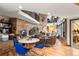 Open-concept living space with a stone fireplace, dining area, and views of the surrounding landscape at 6 Blue Grouse Ridge Rd, Littleton, CO 80127