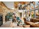 Bright living room featuring a stone fireplace, large windows, and comfortable seating at 6 Blue Grouse Ridge Rd, Littleton, CO 80127