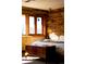 Bedroom with wooden accent wall, bright natural light, and scenic views at 6 Blue Grouse Ridge Rd, Littleton, CO 80127