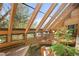 Bright sunroom featuring brick floors, wood beams, and plenty of natural light at 6 Blue Grouse Ridge Rd, Littleton, CO 80127