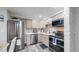 Bright kitchen with stainless steel appliances, tile backsplash, and light wood cabinetry at 8826 E Florida Ave # G12, Denver, CO 80247