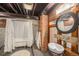 Rustic basement bathroom with clawfoot tub, unique fixtures, and exposed brick at 3019 Meade St, Denver, CO 80211
