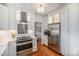 Bright kitchen with stainless steel appliances, white cabinets, modern range hood, and hardwood floors at 3019 Meade St, Denver, CO 80211