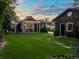 Charming backyard with green grass, stone pathway, pergola and string lights at dusk at 3339 Lowell Blvd, Denver, CO 80211