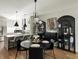 Open dining room with black round table and view to kitchen and breakfast bar at 3339 Lowell Blvd, Denver, CO 80211