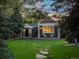 Charming house with manicured lawn, stone walkway, pergola, and Adirondack chairs on the front porch at 3339 Lowell Blvd, Denver, CO 80211