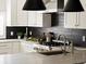 White kitchen with stainless steel oven, black backsplash and modern lighting at 3339 Lowell Blvd, Denver, CO 80211