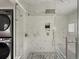 Spa-like shower with glass door, marble tile, and rain shower head, and stacked washer/dryer at 3339 Lowell Blvd, Denver, CO 80211