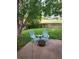 Backyard patio features chairs, fire pit, and view of the lawn and trees at 10386 Ravenswood Way, Highlands Ranch, CO 80130