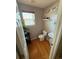 This powder room features stylish fixtures, wood flooring, and a sleek pedestal sink at 10386 Ravenswood Way, Highlands Ranch, CO 80130