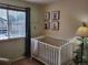 Bright Bedroom features a large window with a white crib, and cute animal artwork at 10386 Ravenswood Way, Highlands Ranch, CO 80130