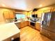 Well-lit kitchen with stainless steel appliances, wood cabinets, granite countertops, and hardwood floors at 10386 Ravenswood Way, Highlands Ranch, CO 80130
