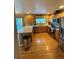 Bright and open kitchen with stainless steel appliances, wood cabinets, hardwood floors and a convenient breakfast bar at 10386 Ravenswood Way, Highlands Ranch, CO 80130