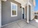 Cozy front porch featuring gray siding, a dark blue door, white trim, and a concrete landing at 5755 S Buchanan Ct # E, Aurora, CO 80016