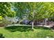 Spacious backyard featuring a lush lawn, mature tree, deck with stairs, and patio, ideal for outdoor living at 17925 E Maplewood Dr, Aurora, CO 80016
