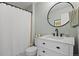 Bathroom with a shower, a toilet, and a vanity with a round mirror at 17925 E Maplewood Dr, Aurora, CO 80016