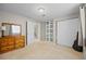 Bright bedroom featuring carpet flooring, closet, and a mirrorred dresser at 17925 E Maplewood Dr, Aurora, CO 80016