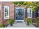 Inviting front entry featuring a classic door with wreath, surrounded by lush ferns and brick facade at 17925 E Maplewood Dr, Aurora, CO 80016