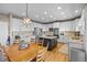 White kitchen with stainless steel appliances, kitchen island, and a wooden kitchen table set at 17925 E Maplewood Dr, Aurora, CO 80016