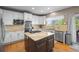 Bright white kitchen featuring stainless steel appliances, kitchen island, granite countertops, and light backsplash at 17925 E Maplewood Dr, Aurora, CO 80016