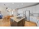 Open concept kitchen features white cabinets, stainless steel appliances, kitchen island, and wood floors at 17925 E Maplewood Dr, Aurora, CO 80016