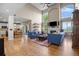 Open-concept living room featuring tall windows, fireplace, wood floors, and access to the kitchen at 17925 E Maplewood Dr, Aurora, CO 80016
