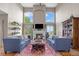 Bright living room with fireplace, tall windows, hardwood floors, and blue sofas at 17925 E Maplewood Dr, Aurora, CO 80016