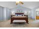 Well-lit main bedroom with a large bed, bench, bedside tables and blue accent pillows at 17925 E Maplewood Dr, Aurora, CO 80016