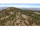 Wonderful aerial image of the home nestled atop a lush green mountain at 5197 Bear Mountain Dr, Evergreen, CO 80439