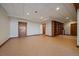 Spacious basement area with tile flooring, wood trim, and a built-in bookcase for storage at 5197 Bear Mountain Dr, Evergreen, CO 80439