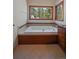 A relaxing soaking tub area featuring wood accents and views of the surrounding forest at 5197 Bear Mountain Dr, Evergreen, CO 80439