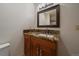 Bathroom vanity with granite counters, wood cabinets and large mirror at 5197 Bear Mountain Dr, Evergreen, CO 80439