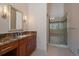 Modern bathroom with a glass-enclosed shower, granite counters, and wood cabinetry at 5197 Bear Mountain Dr, Evergreen, CO 80439
