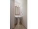 A pedestal sink with modern light fixture and mirror in half bathroom at 5197 Bear Mountain Dr, Evergreen, CO 80439