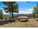 This property includes a gorgeous deck with black metal railings overlooking the lush green valleys at 5197 Bear Mountain Dr, Evergreen, CO 80439