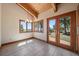 Bright dining area with tiled flooring, wood trim, a modern light fixture, and an expansive backyard view at 5197 Bear Mountain Dr, Evergreen, CO 80439