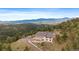 Stunning home boasts serene mountain views from a private, elevated location with a deck and a circular driveway at 5197 Bear Mountain Dr, Evergreen, CO 80439