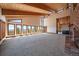Spacious living room with a brick fireplace, vaulted wood ceilings, and walls of windows overlooking mountain views at 5197 Bear Mountain Dr, Evergreen, CO 80439