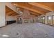 Expansive living room with a unique brick fireplace, bar, vaulted wood ceilings, and views of the wooded hillside at 5197 Bear Mountain Dr, Evergreen, CO 80439