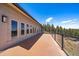 Long patio with glass railing and view of trees at 5197 Bear Mountain Dr, Evergreen, CO 80439