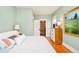 Bright bedroom features a closet, hardwood floors, light teal paint, and modern furnishings at 2228 N Race St, Denver, CO 80205