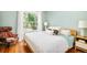 Bedroom with light teal walls, a queen bed, and a large window showcasing a tree-lined street at 2228 N Race St, Denver, CO 80205