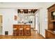 Open kitchen with wood beams, stainless appliances, breakfast bar with seating, and hardwood floors at 2228 N Race St, Denver, CO 80205
