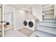 Clean laundry room features a washer and dryer, stairs, and a glimpse into the bedroom at 2228 N Race St, Denver, CO 80205