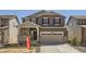 Two-story home featuring a two-car garage, stone accents, and neutral brown color scheme at 710 N Deer Park, Watkins, CO 80137